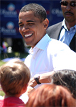 Barack Obama smiling at children nearby