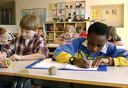 Children writing in notebooks in a classroom