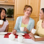 Women enjoying coffee together in kitchen