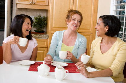Women enjoying coffee together in kitchen