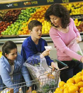 Mother and her two children shopping for fruit