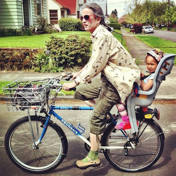 Mom at the helm, kid in the rear rack bicycle seat.