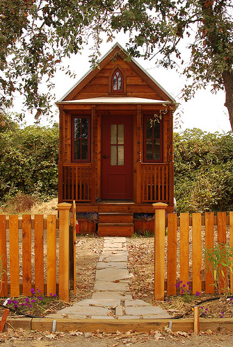 A tiny house with a picket fence.