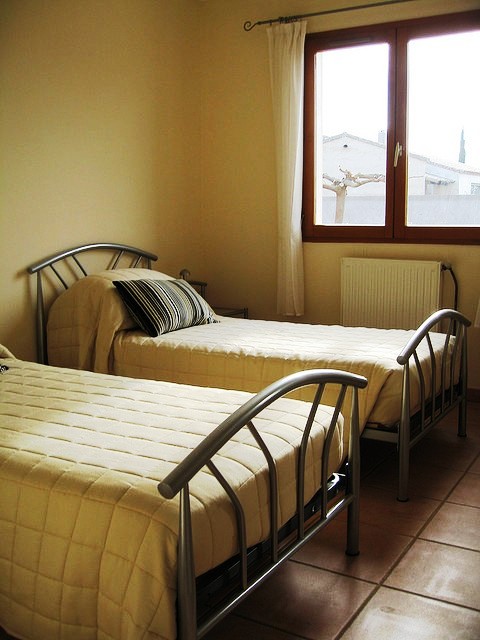 A pair of twin beds in an unoccupied room.