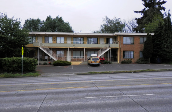 Motel-style apartment with parking in front.