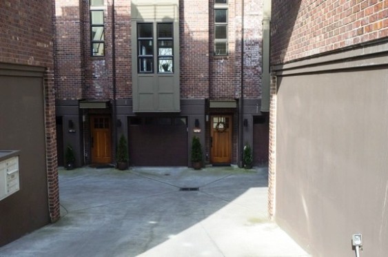 A barren scene inside a parking-court access to an apartment building.