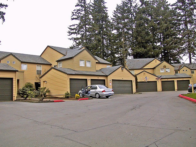 A row of garages dominates the entrance to an apartment complex.