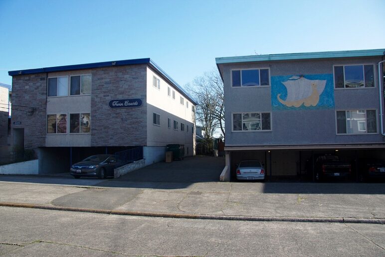Two apartment buildings with dingbat parking.