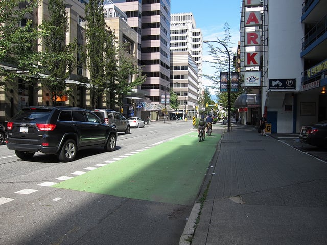 The SUV yields the right-of-way to bikes as the driver waits to turn into the parking garage (1). Photo by Alyse Nelson, used with permission.