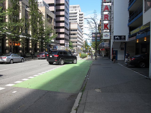 The SUV yields the right-of-way to bikes as the driver waits to turn into the parking garage (2). Photo by Alyse Nelson, used with permission.