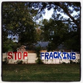 Homemade anti-fracked gas sign that says "Stop Fracking" sign on a residential fence.