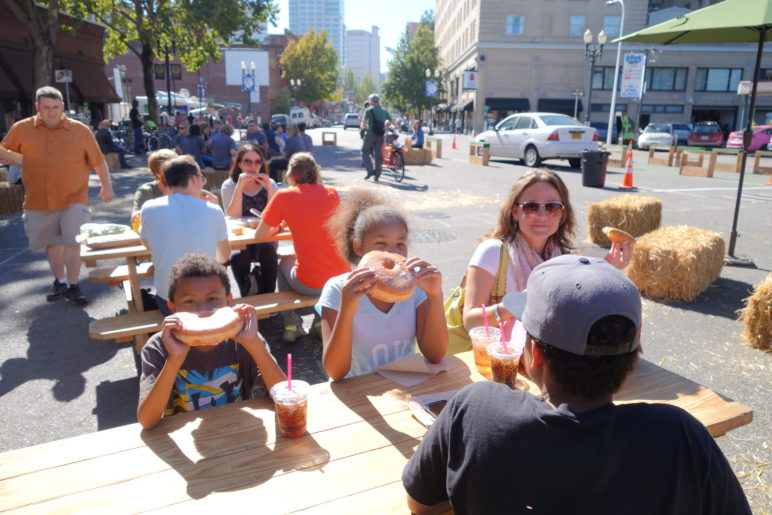 families eating donuts at temporary plaza in downtown Portland
