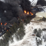 a large mass of oil car trains surrounded by smoke and fire