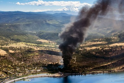 aerial view of plume of smoke from oil car next to a river