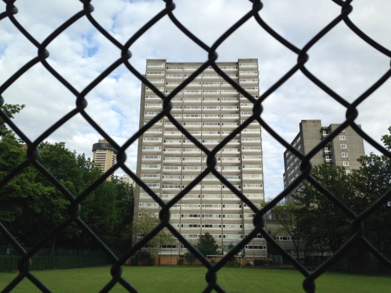 20+ story building behind a chain link fence