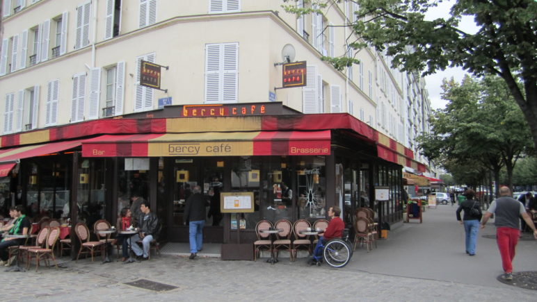 A corner neighborhood bistro called "Bercy Cafe" with a red and yellow awning.