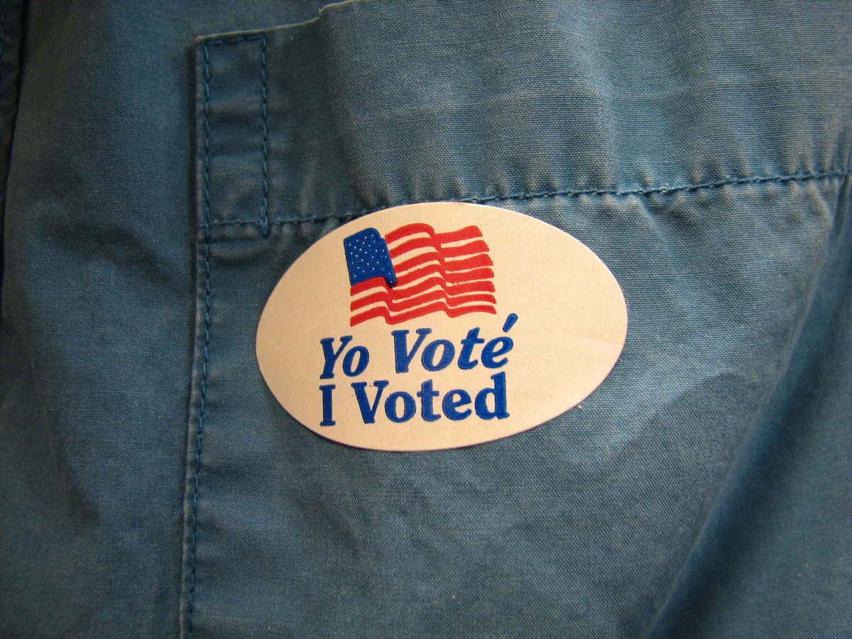 Photo of a "Yo Vote | I Voted" sticker on a faded blue shirt pocket.