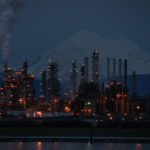 Photo of oil refinery in Anacortes at night, with a plume of smoke emanating from one of the stacks