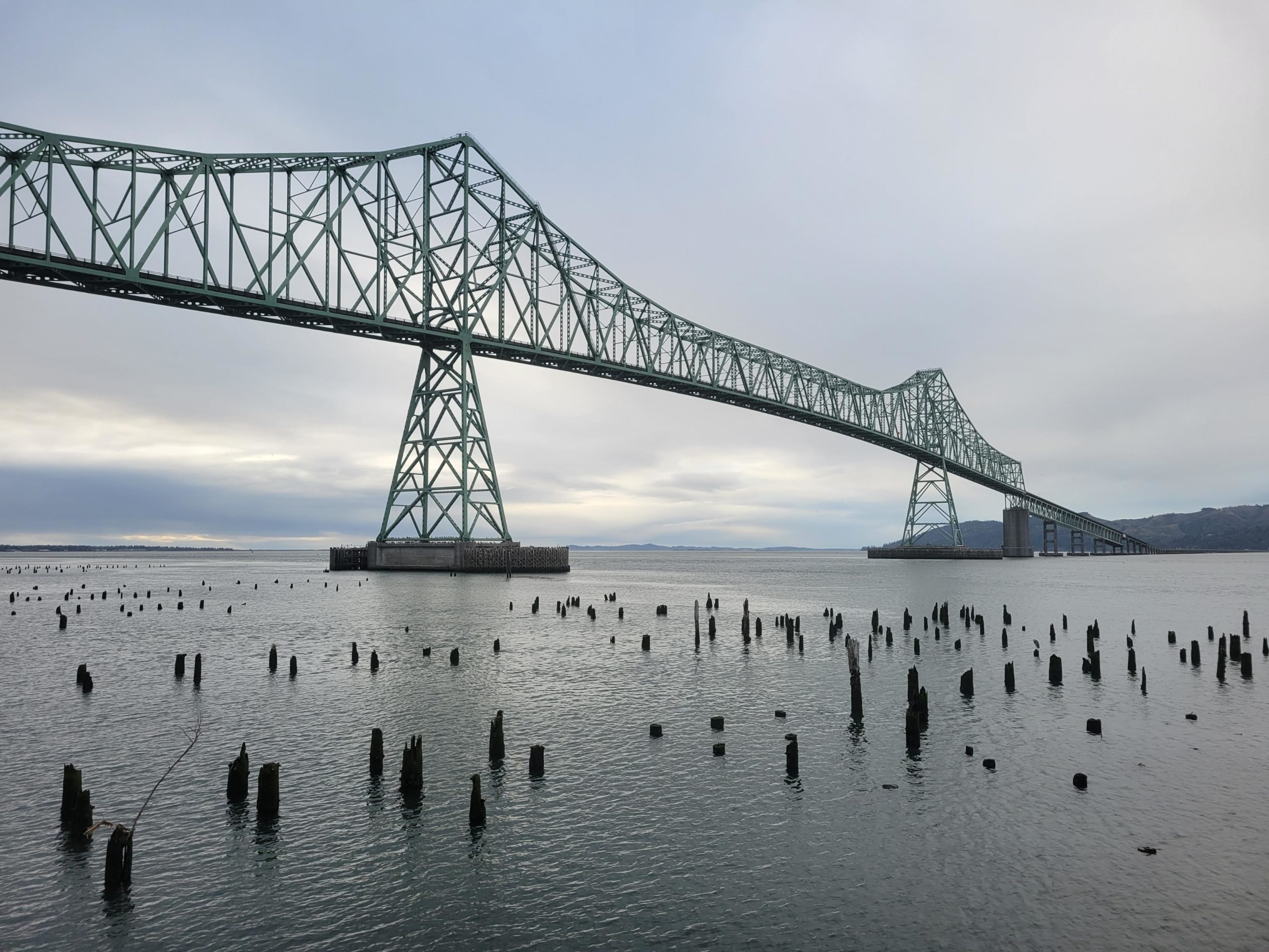 Photo of Astoria-Megler Bridge with pilings in the foreground.