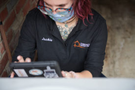 Photo of Community Energy Project worker doing a diagnotic in a home with a tablet computer