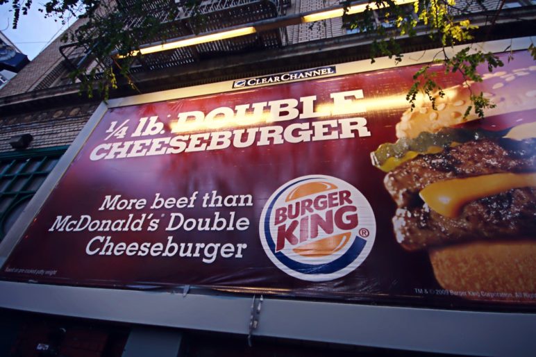 Sign for Burger King advertising their burgers in comparison to McDonald's