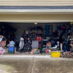 Photo of an open garage door featuring an impressive collection of vintage clutter