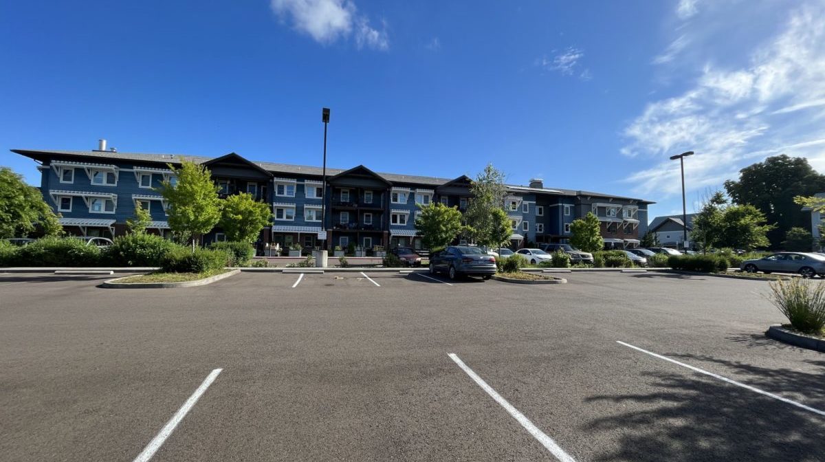 Photo of an empty lot on an otherwise sunny day at an affordable apartment