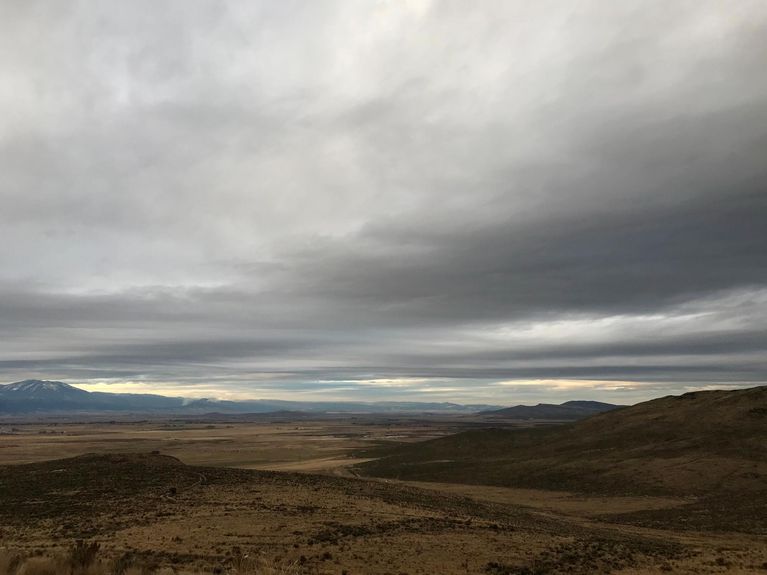 View of plains and hills on a cloudy, grey day.