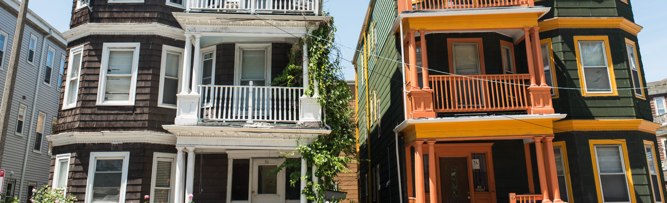 Two multi-unit housing buildings side-by-side on a sunny day