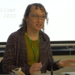Esme D. Miller presents her research on body, gender, and sexuality in early 20th-century logging camps and mill towns in the Pacific Northwest, and the urban living conditions of those who did not fit the mold of class, race, and sexuality (screenshot from video of session).