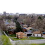 An overhead photo of Boise, with small single-detached homes in the foreground and downtown offices in the distance.