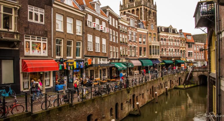 A row of three- and four-story mixed-use buildings along a canal in Utrecht, Netherlands.