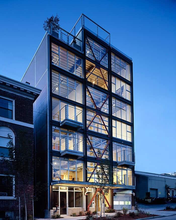 East Union Lofts. Photograph courtesy of James F. Housel and Miller Hull. Photo of a 7-story building at dusk. Large windows make up the side, and what looks like refurbished industrial-styled building aesthetics.