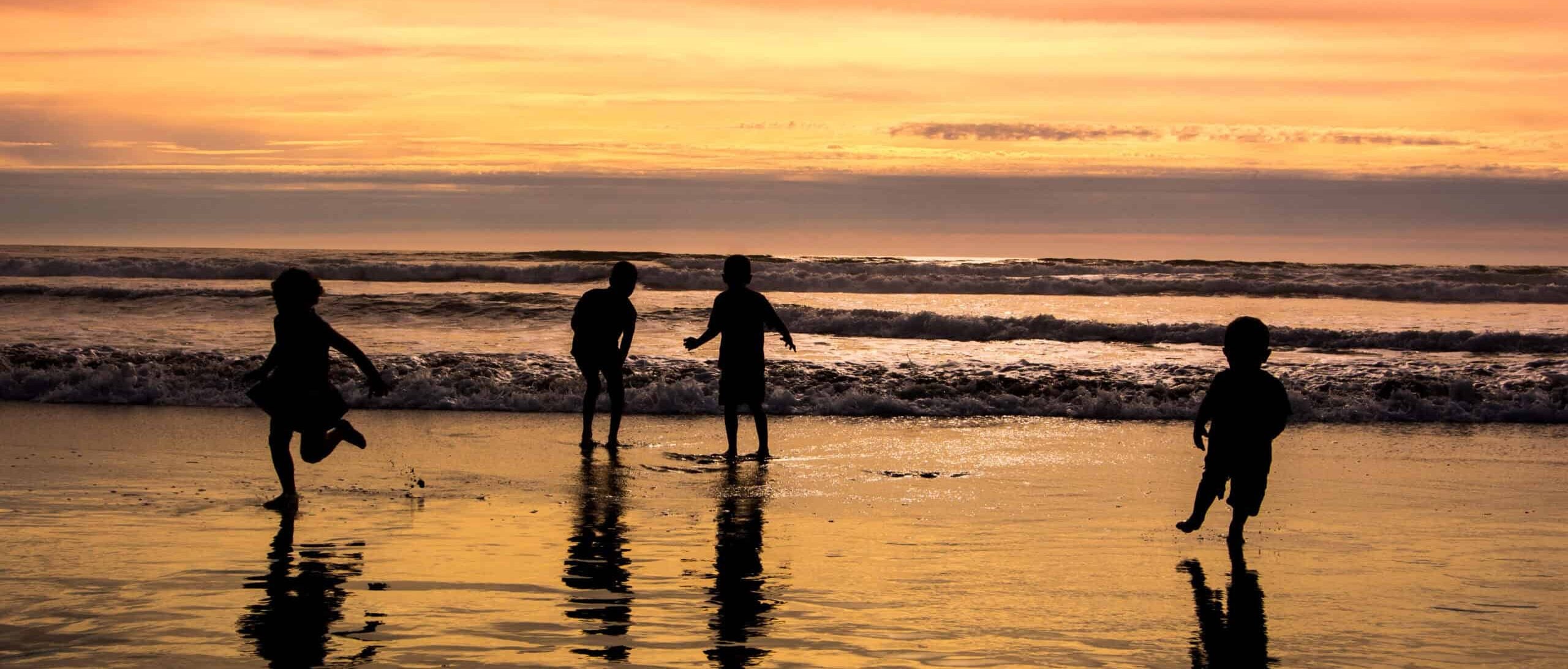 Kids playing on beach. Photo by B Calkins, via Shutterstock.