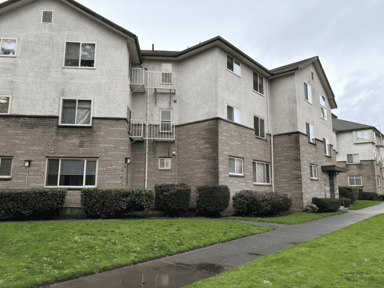 A Seattle apartment building with low-efficiency electric baseboard heating and no cooling. Window heat pumps would not fit the building's windows, which open horizontally.