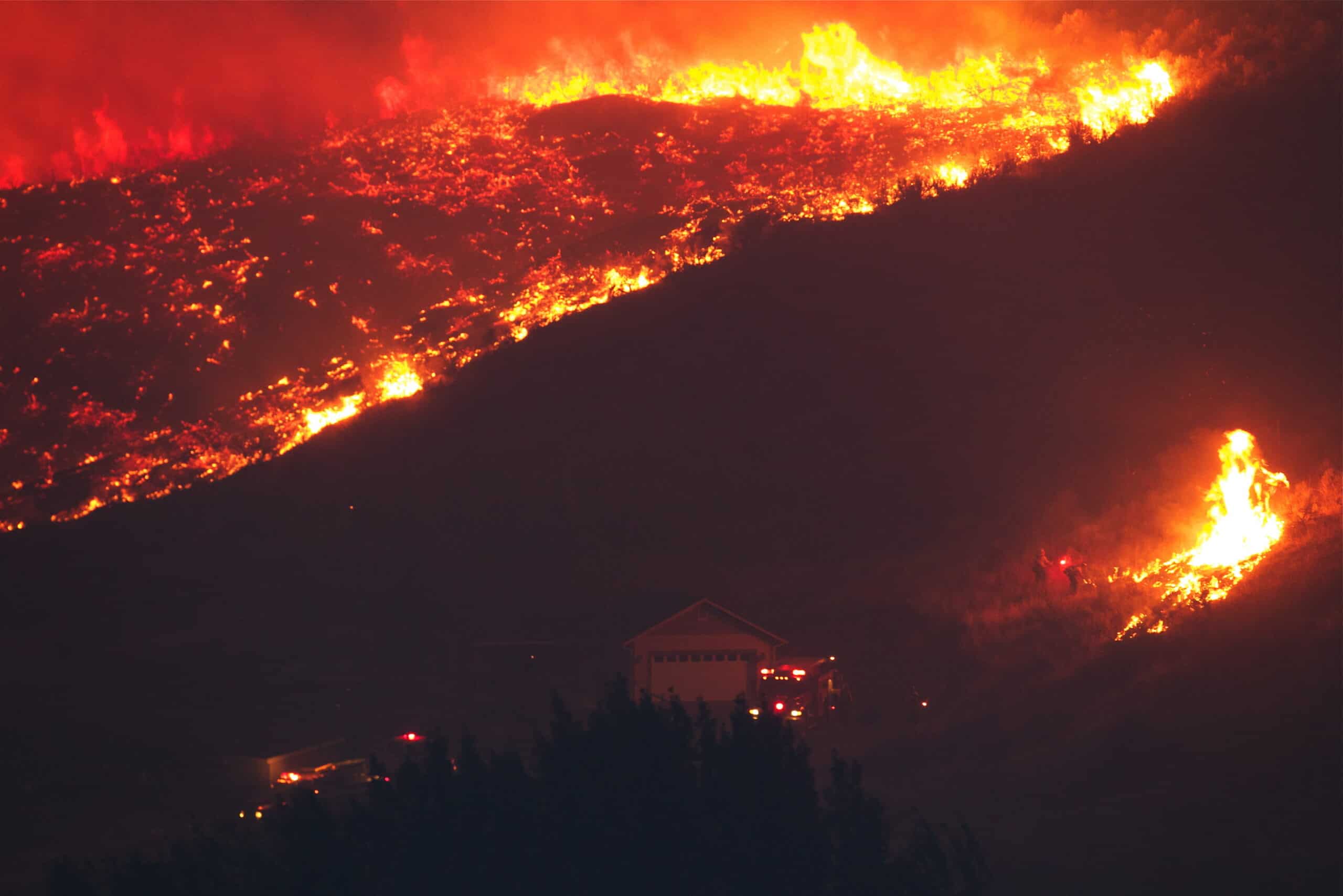 Firefighters battling the 2014 Carlton Complex fire try to save a home from wildfire as flames rapidly approach. Photo by Tom Reichner.