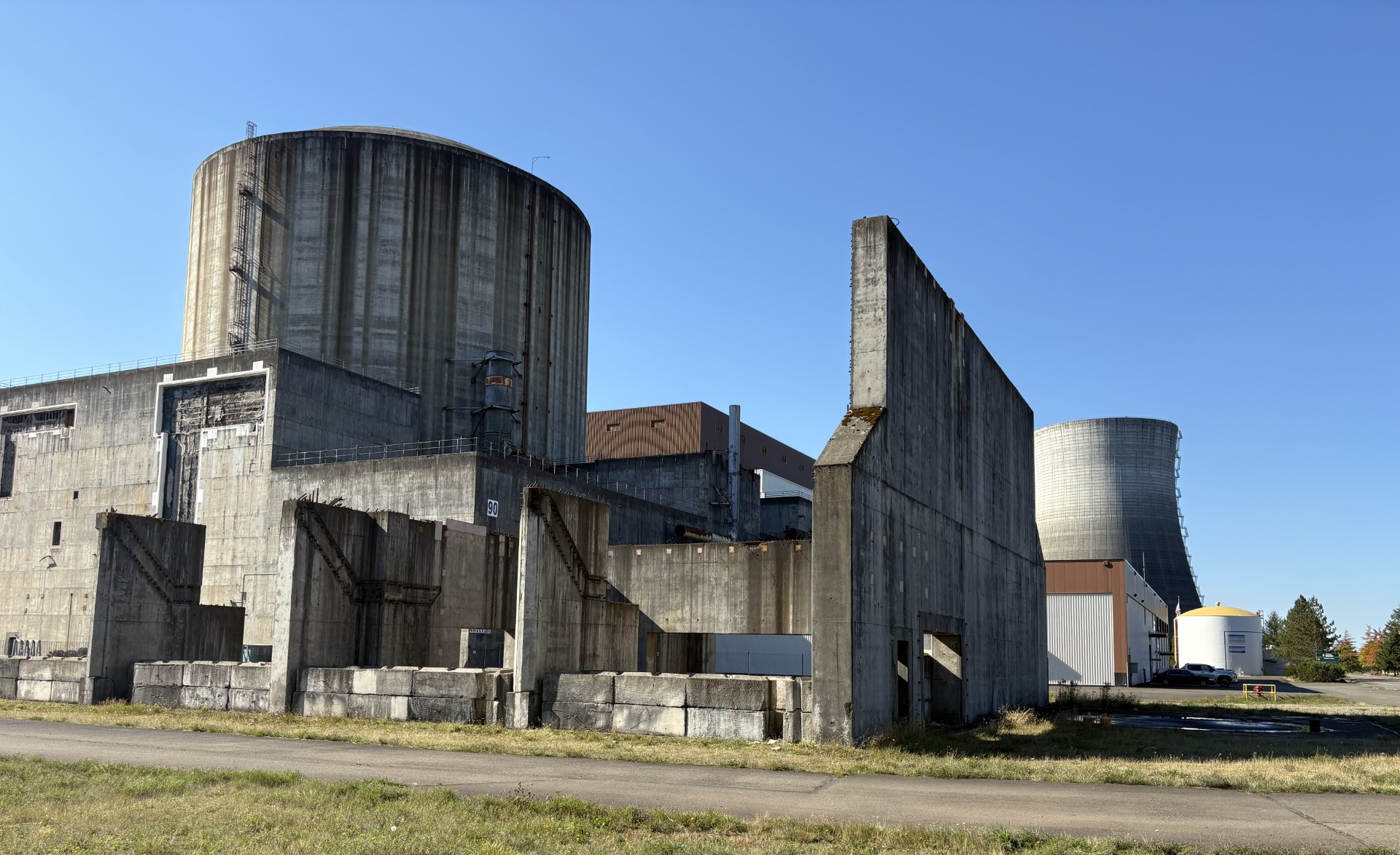 An abandoned, unfinished nuclear power facility, in Satsop, Washington, photographed in 2025. Echoing the 1970s WPPSS fiasco, in which utilities used inflated power demand forecasts to justify five nuclear plants—only one of which was completed and that ratepayers are still paying off—utilities today are relying on speculative projections to rally for more gas power plants. Photo by Emily Moore.