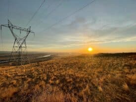 A Northwest electric transmission line at sunset. The region needs more grid capacity to bring clean power to the region’s residents and honor state climate goals. Photo by Amy Homan, cc.