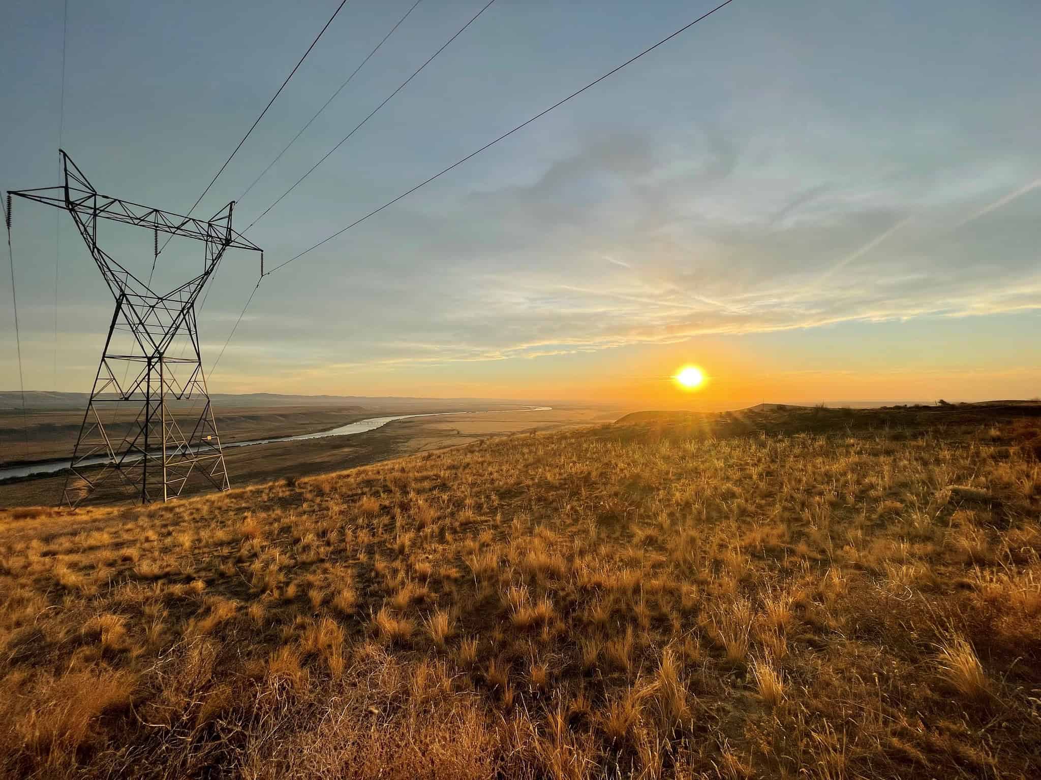 A Northwest electric transmission line at sunset. The region needs more grid capacity to bring clean power to the region’s residents and honor state climate goals. Photo by Amy Homan, cc.