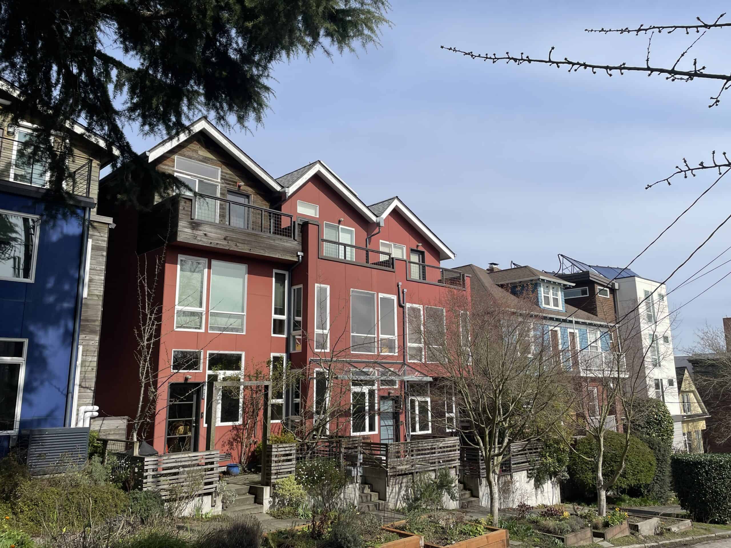 A block of homes in Seattle’s Capitol Hill neighborhood that would prove inaccessible or challenging to anyone who cannot easily navigate stairs: a row of three-story townhouses built in 2011, plus two older detached houses, flanking a four-story apartment building with 27 homes and no elevator, built in 2018. Photo by Dan Bertolet.