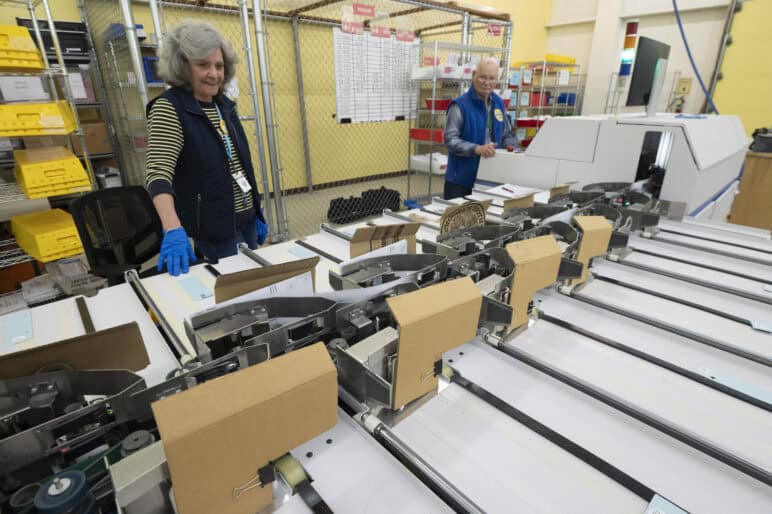 Election workers watch ballots being sorted in Anchorage, Alaska. The state’s model top-four primaries and ranked choice general elections continue to deliver benefits for voters and leaders alike. Photo by Michael Dinneen, all rights reserved.