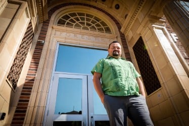 Professor Erim standing in front of doors at the university