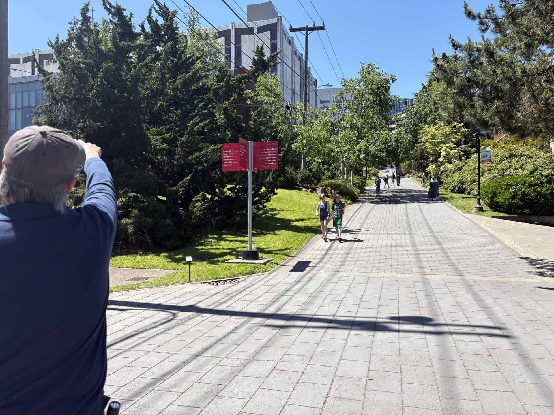 Seattle University staff point out the proposed location of Puget Sound Energy’s heating and cooling pilot, catalyzed by Washington’s thermal energy network law. Photo by Emily Moore.