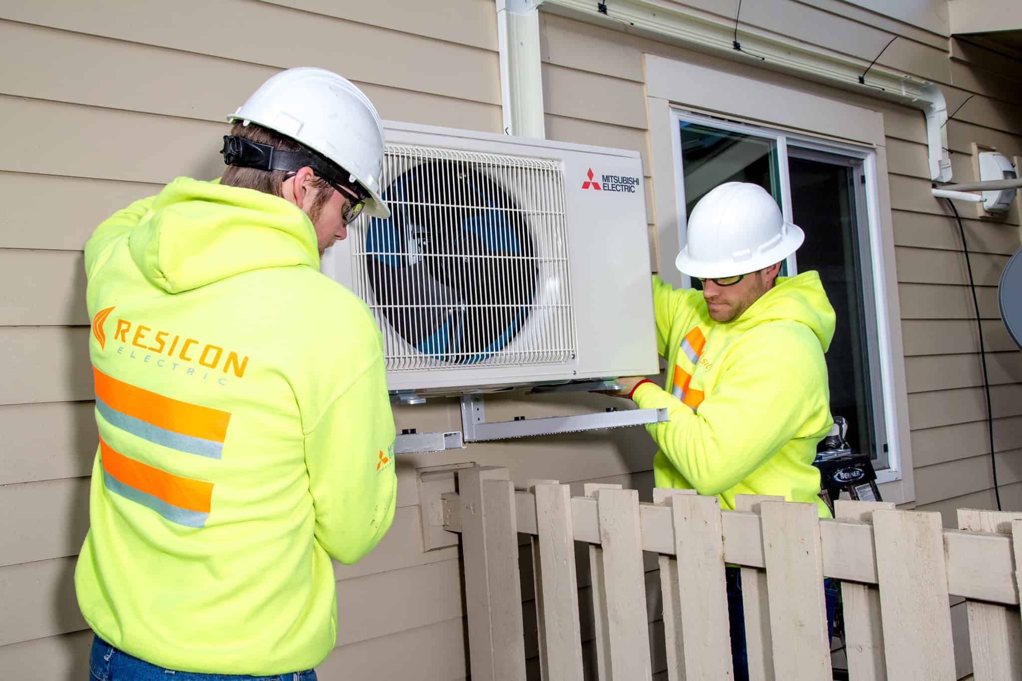 Construction workers help install new heat pumps for residents in South Seattle
