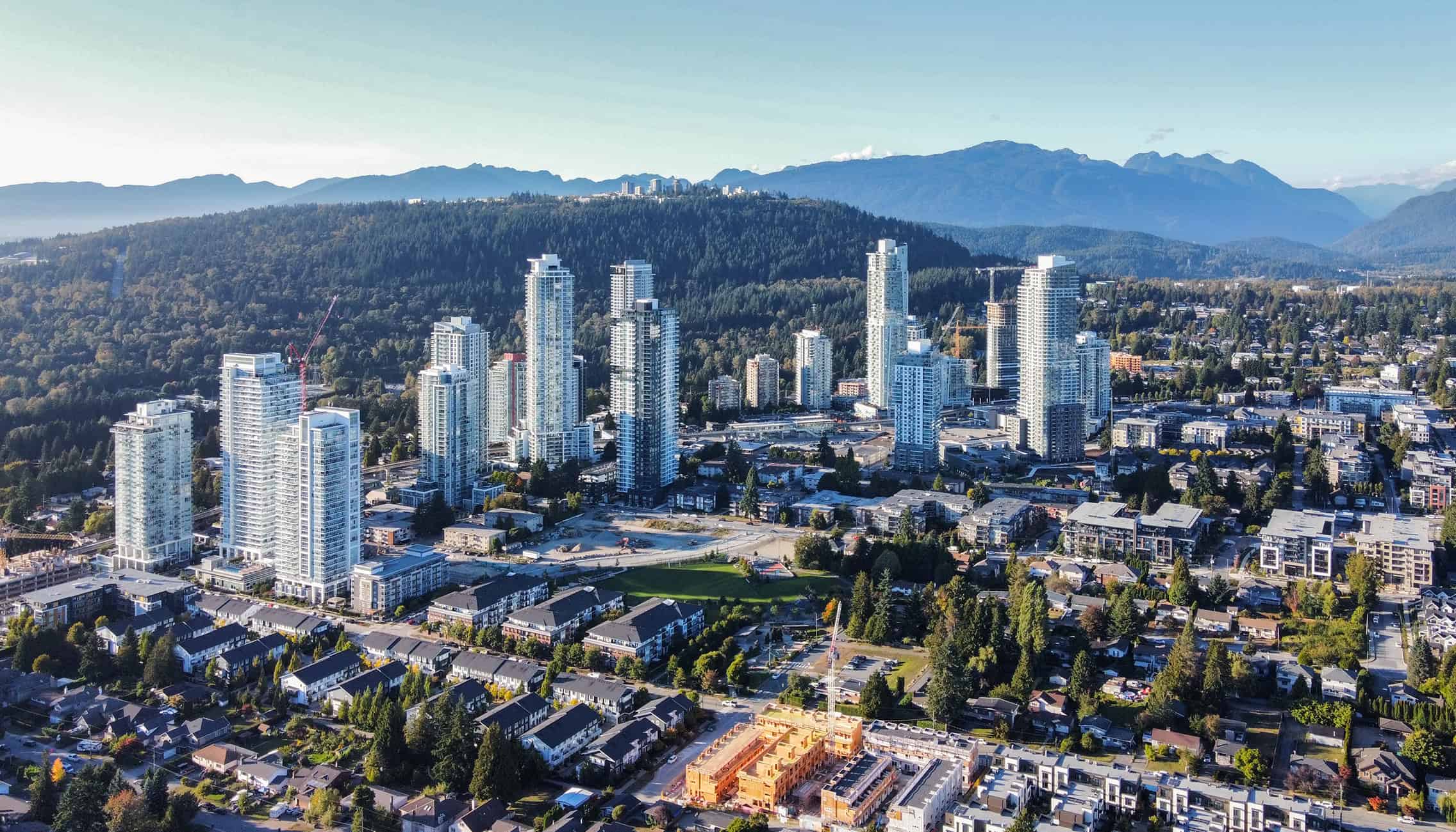 Homes abut a SkyTrain line in the TOD neighborhood of “Burquitlam” in Coquitlam, BC (2025). Photo by Canmenwalker, cc, via Wikimedia commons.   