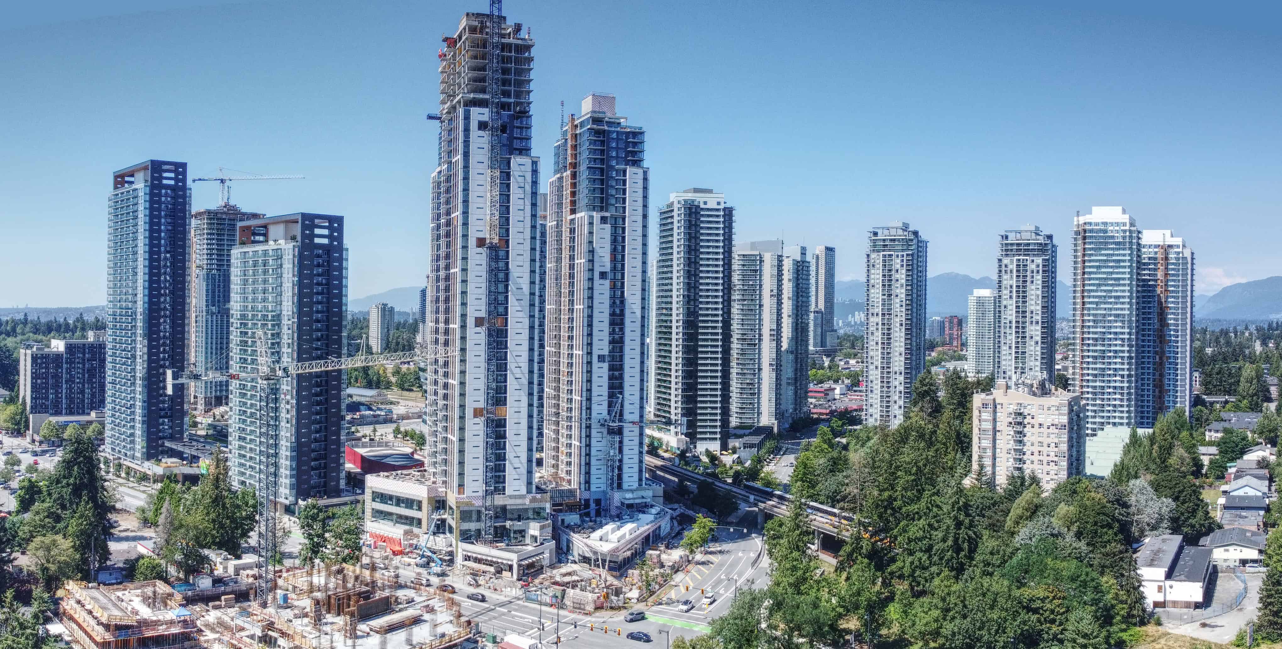 Apartments under construction along a SkyTrain line in Surrey, BC, in 2024. Photo by Northwest via Wikimedia Commons. 