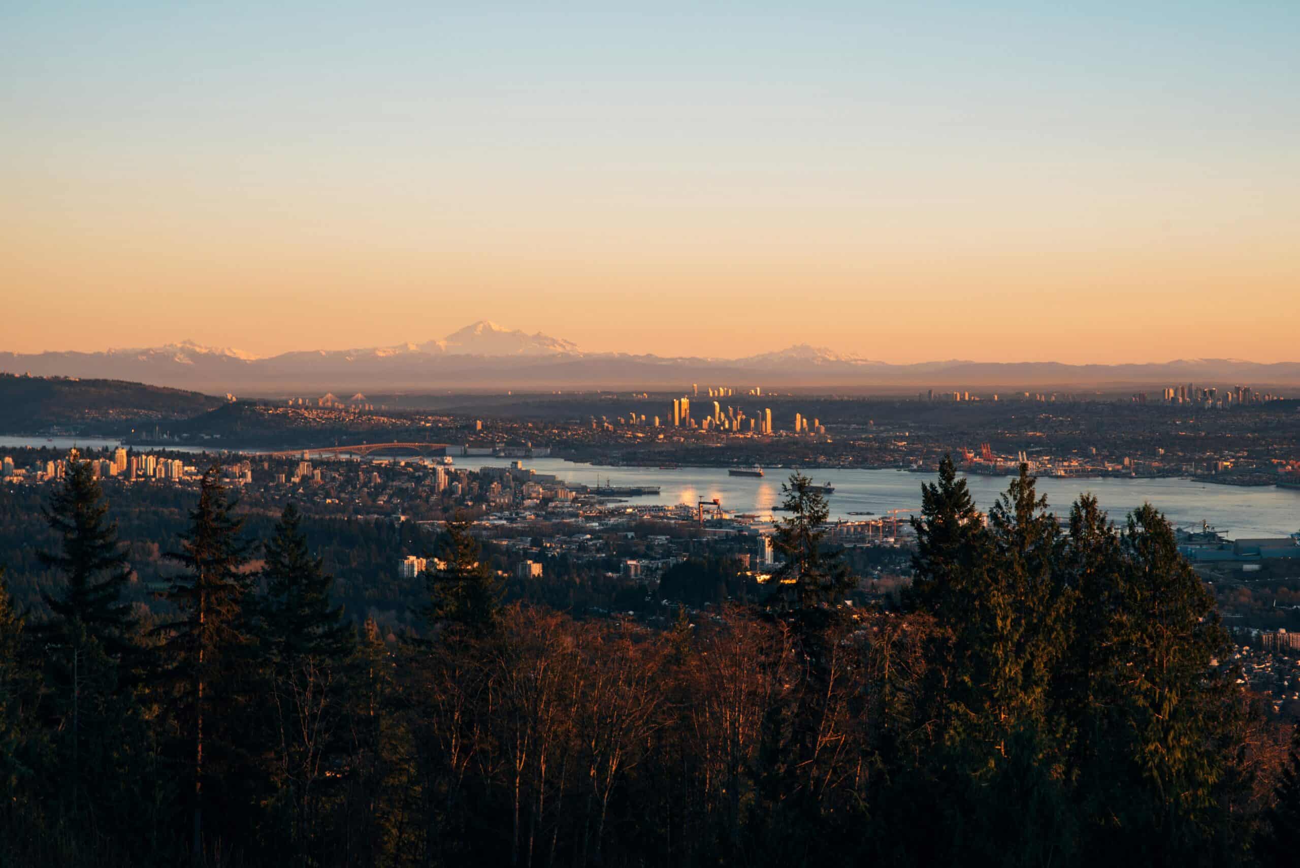 A view of Metro Vancouver, including several pockets of TOD-facilitated homes, looking southward towards Washington state. Photo courtesy of Tim Woolliscroft via Unsplash.